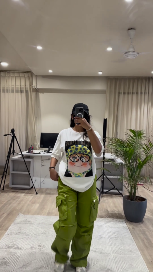Urban Chic Outfit: White Graphic Tee, Rust Cargo Pants, and Black Cap - Image 5