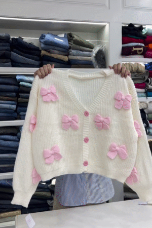 Cream Chunky‑Knit Cropped Cardigan with 3D Pink Bow Appliqués and Contrast Buttons for Cute Winter Looks” 🎀